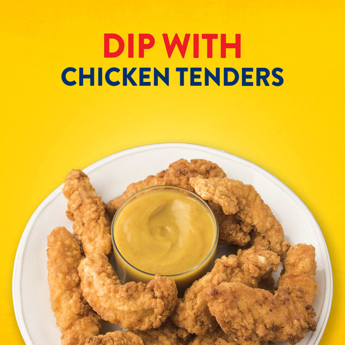 A white plate of crispy chicken tenders is arranged around a small bowl of Frenchs Brown Honey Mustard 12 Oz, ready for dipping.