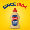 A bottle of Frenchs Beige Dijon Chardonnay Mustard 12 Oz is centered against a bright yellow background with the words Since 1904 arched above it.