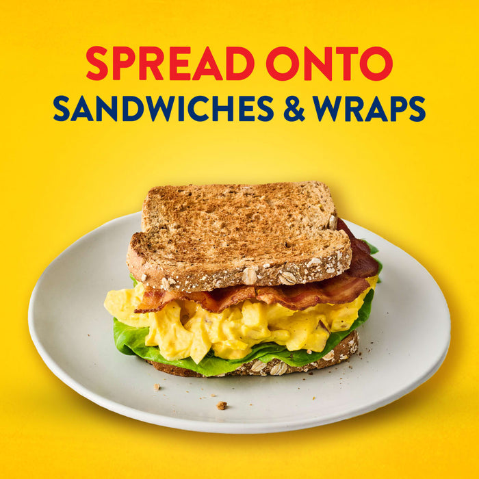 A delicious breakfast sandwich with eggs and bacon on a plate demonstrates a serving suggestion for Frenchs Beige Dijon Chardonnay Mustard 12 Oz, under the text Spread onto sandwiches &amp; wraps.