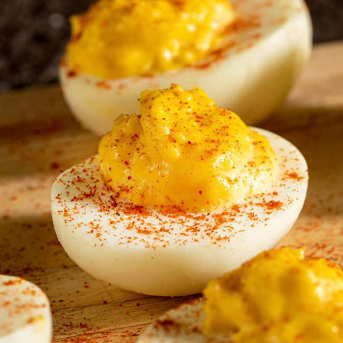 ['Deviled eggs with paprika sprinkled on top.']