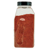 ['A glass jar filled with red chili powder.']