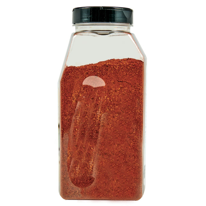 ['A glass jar filled with red chili powder.']