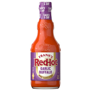 A glass bottle of Franks Red Hot Garlic Buffalo Wing Hot Sauce Regular 12 Oz is shown against a white background, featuring its signature purple label.