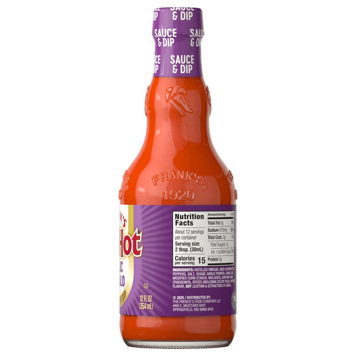 A glass bottle of Franks Red Hot Garlic Buffalo Wing Hot Sauce Regular 12 Oz is shown from the back, displaying the purple and white nutrition facts and ingredients label.