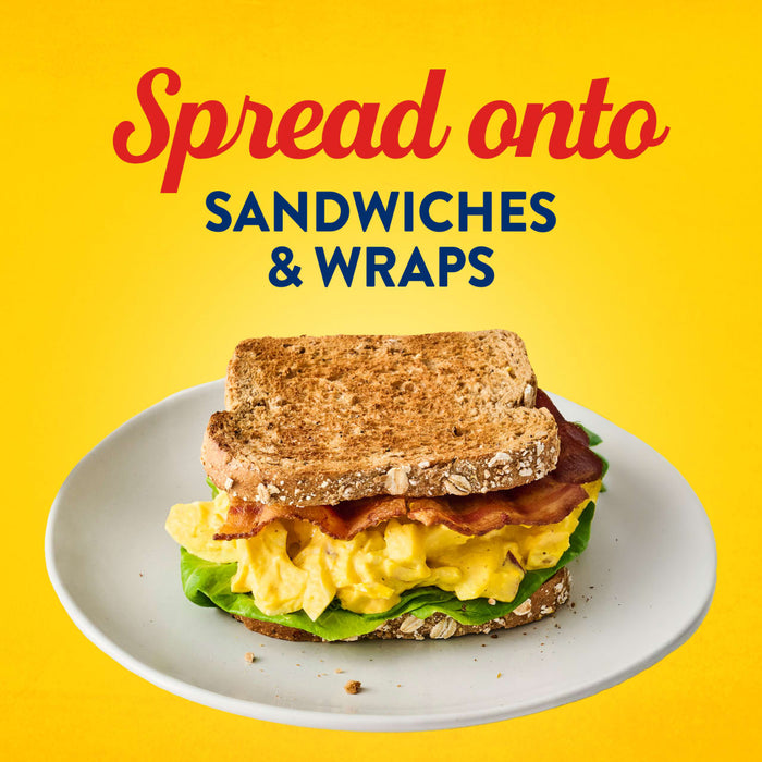 A toasted egg salad and bacon sandwich on a white plate illustrates how to use Frenchs Yellow Regular Mustard 12 Oz as a spread for sandwiches and wraps.