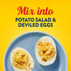 Two deviled eggs sprinkled with paprika on a blue plate illustrate how to mix Frenchs Yellow Regular Mustard 12 Oz into classic side dishes.