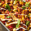 ['A close-up of nachos with toppings like cheese, sour cream, tomatoes, corn, and avocado.']