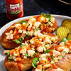 ["Three shrimp rolls topped with Frank's RedHot sauce and garnished with green onions and spinach."]