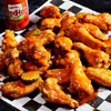 ["A plate of buffalo wings with Frank's RedHot sauce."]