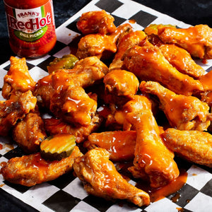 ["A plate of buffalo wings with Frank's RedHot sauce."]