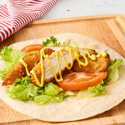 A fresh tortilla wrap filled with crispy chicken, lettuce, and tomato is drizzled with a tangy sauce from a Frenchs Dill Pickle Sandwich Spread Regular Inverted Squeeze Bottle Rp 12 Oz.