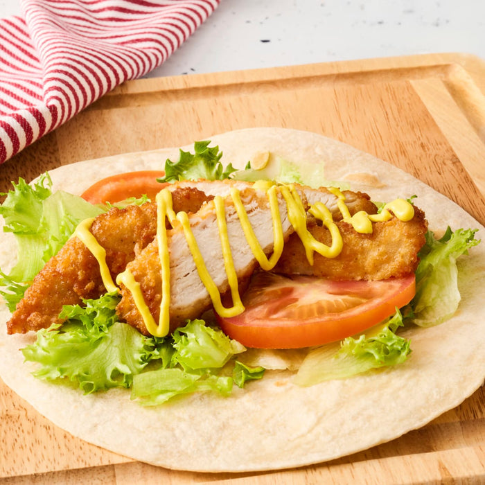 A fresh tortilla wrap filled with crispy chicken, lettuce, and tomato is drizzled with a tangy sauce from a Frenchs Dill Pickle Sandwich Spread Regular Inverted Squeeze Bottle Rp 12 Oz.