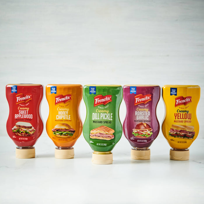 Five different flavors of French's mustard are shown in squeeze bottles.