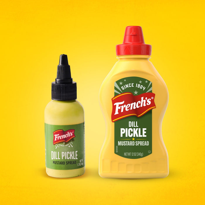 Two bottles of French's Dill Pickle Mustard Spread, a large Frenchs Dill Pickle Sandwich Spread Regular Inverted Squeeze Bottle Rp 12 Oz and a smaller travel-size bottle, are shown side-by-side against a yellow background.