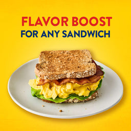 A delicious bacon and egg salad sandwich on a white plate demonstrates how Frenchs Dill Pickle Sandwich Spread Regular Inverted Squeeze Bottle Rp 12 Oz can provide a flavor boost for any sandwich.
