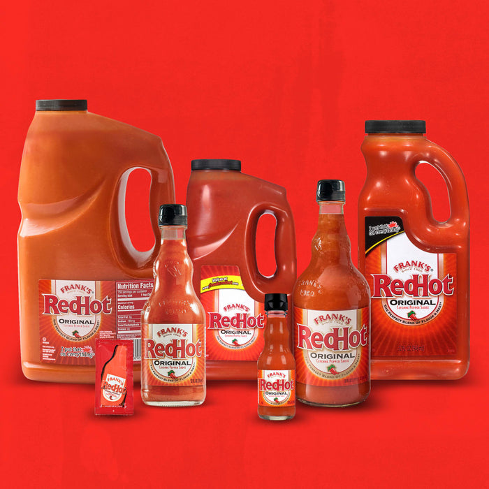 A collection of Frank's RedHot bottles of different sizes.