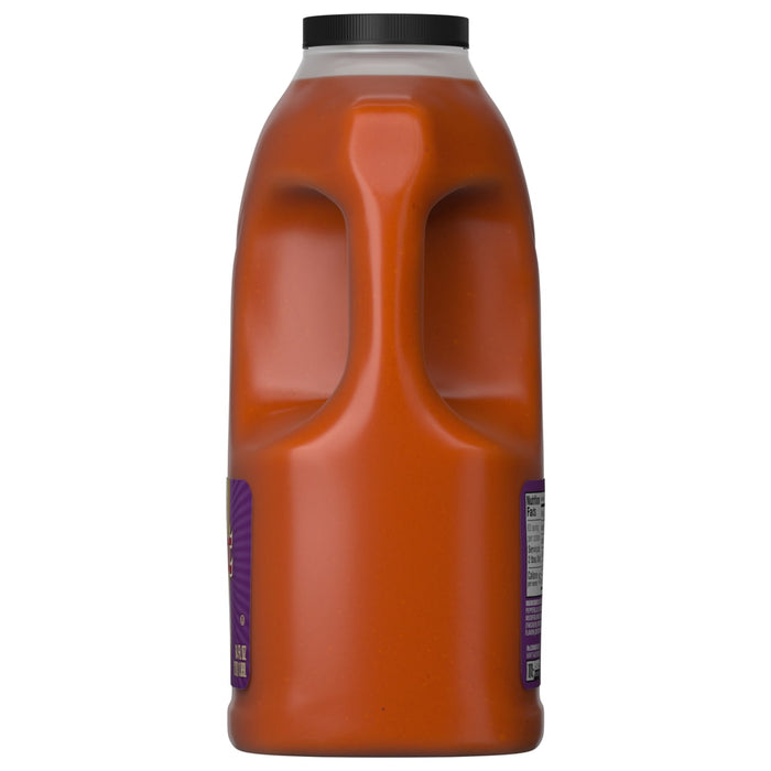 A side view of a large jug of Franks Red Hot Garlic Buffalo Wing Hot Sauce Regular 64 Oz shows the built-in handle and the nutrition facts label.