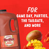 A large jug of Franks Red Hot Mango Habanero Wing Hot Sauce Regular 64 Oz is displayed against a vibrant red background alongside fresh mango and habanero peppers to highlight its use for game day and parties.