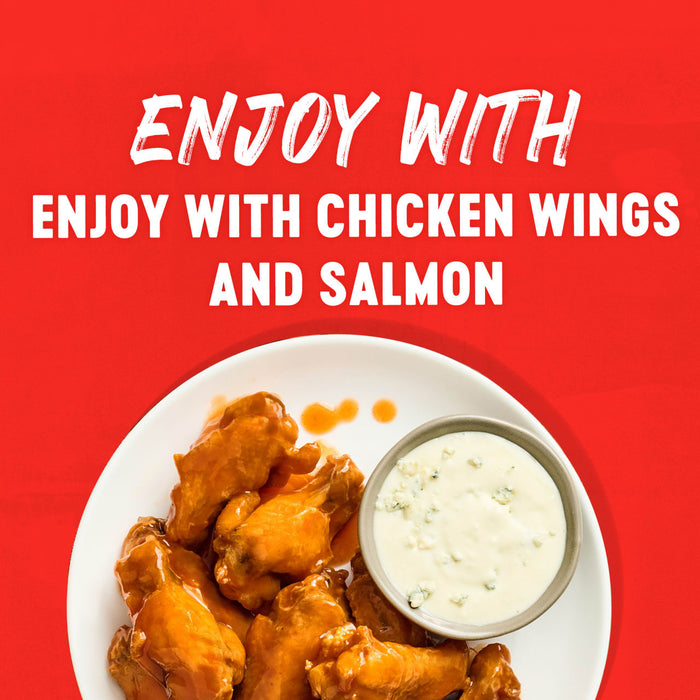 A plate of glazed chicken wings served with a side of blue cheese dressing illustrates how to enjoy Franks Red Hot Mango Habanero Wing Hot Sauce Regular 64 Oz with chicken wings and salmon.