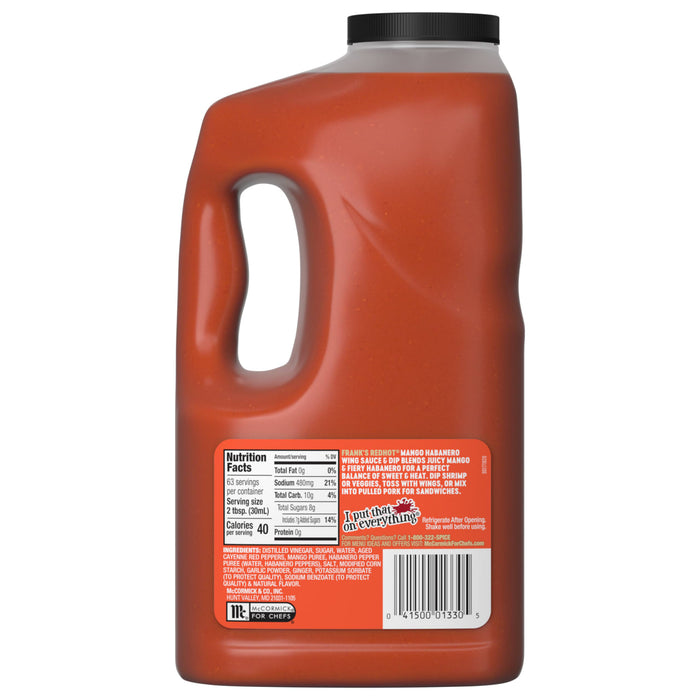 A large, clear jug of Franks Red Hot Mango Habanero Wing Hot Sauce Regular 64 Oz is shown, with the label detailing the nutritional information, ingredients, and serving suggestions.