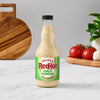 A bottle of Frank's RedHot Garlic Parmesan Wing Sauce stands on a counter.