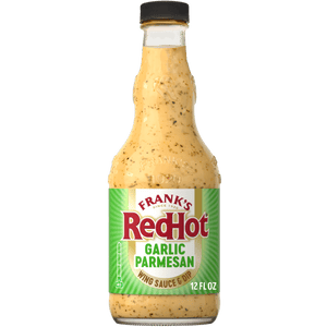 A bottle of Frank'S Redhot Garlic Parmesan Wings Sauce 12 Fl Oz, featuring a creamy, light yellow sauce with visible specks of herbs and spices, and a green and white label.