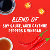 This image showcases the ingredients of a blend of soy sauce aged cayenne peppers and vinegar with a red background.