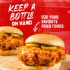 A sandwich with fried chicken and pickles on a bun with the text Keep a bottle on hand for your favorite fried foods.