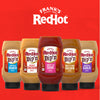 Five bottles of Franks RedHot Dipn sauces in various flavors including Buffalo Ranch Secret Chicken Sweet n Sour Sweet &amp; Tangy Golden and Roasted Garlic are displayed against a red background.