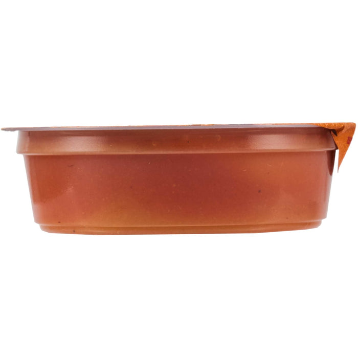 A side view of a small, sealed container of food, likely a dip or sauce.