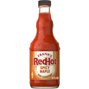 A glass bottle of Frank'S Redhot Spicy Maple Wings Sauce 12 Fl Oz, featuring a red and gold label with the brand name and product description.