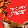 Wings, nuggets, and tenders are being tossed in a bowl with sauce.