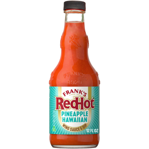 A bottle of Frank'S Redhot Pineapple Hawaiian Wings Sauce 12 Fl Oz is shown, filled with a bright orange-red sauce and featuring a label with a teal and yellow design.