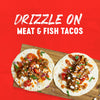 A vibrant image showcasing two tacos filled with meat and fish, drizzled with a flavorful sauce, suggesting a delicious topping option.