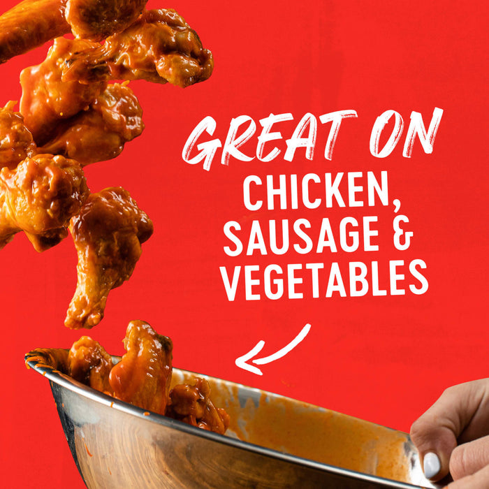 Chicken wings are tossed in a bowl with a sauce that is great on chicken, sausage, and vegetables.