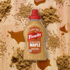 A spilled mixture of brown sugar and liquid creates a sticky mess on a wooden surface.