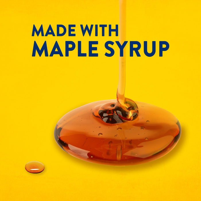 Maple syrup is drizzled onto a yellow surface, highlighting the product's key ingredient.