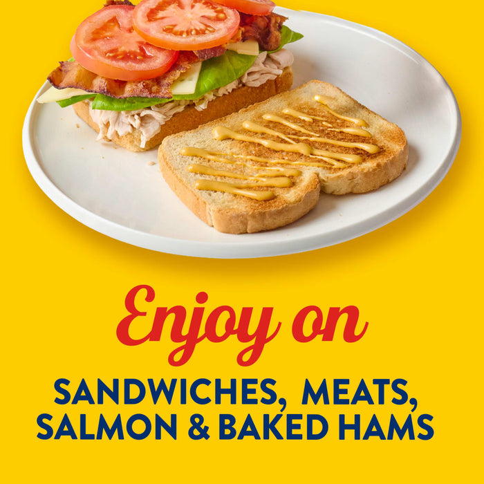A sandwich with tomatoes and bacon, next to a piece of bread with mustard, promoting the use of the product on sandwiches, meats, salmon and baked hams.