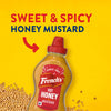 Frank's Sweet &amp; Spicy Honey Mustard bottle on a yellow background with mustard seeds.