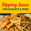 A variety of fried foods like nuggets and fries are arranged around a bowl of dipping sauce, perfect for a snack.