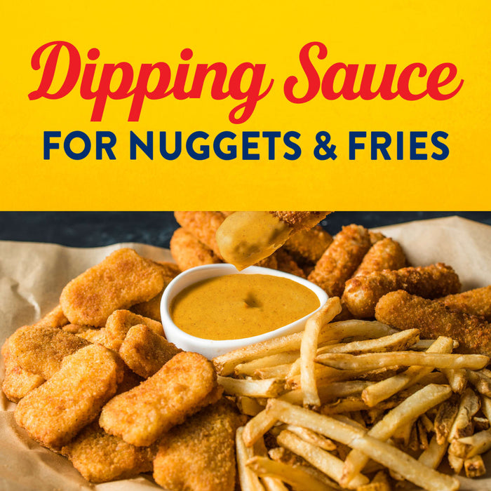 A variety of fried foods like nuggets and fries are arranged around a bowl of dipping sauce, perfect for a snack.