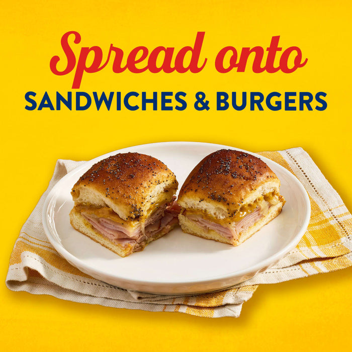 A close-up of two sandwiches on a plate, suggesting the product can be spread onto sandwiches and burgers.