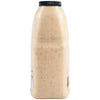 A side profile of a large, clear bottle filled with Cattlemens Alabama White Oz, a creamy white sauce with dark specks.