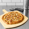 A delicious chicken and bacon pizza, featuring a creamy white sauce made with Cattlemen'S Alabama White Bbq Sauce, 0.5 Gal, is presented on a wooden pizza peel.