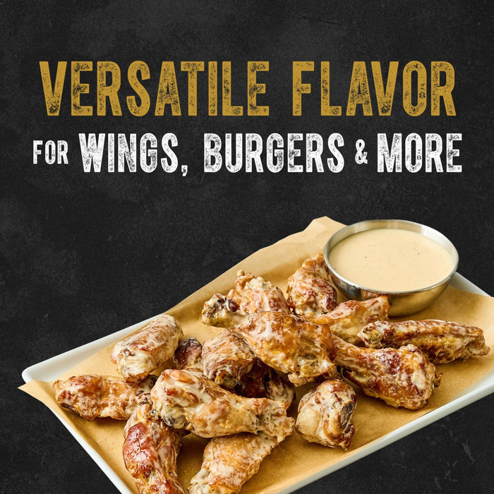 A plate of chicken wings coated in the creamy Cattlemen'S Alabama White Bbq Sauce, 0.5 Gal, is shown with the text Versatile flavor for wings, burgers &amp; more.