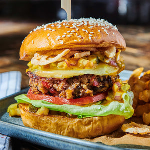 ['A close-up of a delicious burger with lettuce, tomato, and a patty on a sesame seed bun.']