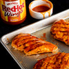 A close-up of three grilled chicken breasts covered in Franks RedHot Buffalo Wing Sauce.