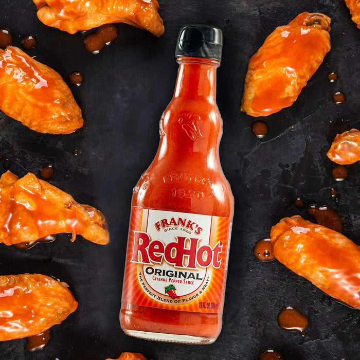 A bottle of Franks RedHot Original Cayenne Pepper Sauce with chicken wings.