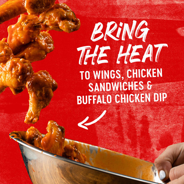 Buffalo wings falling into a bowl with the text Bring the Heat to Wings, Chicken Sandwiches &amp; Buffalo Chicken Dip on a red background.