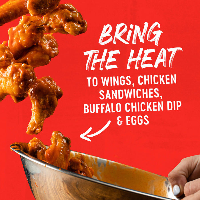 Buffalo wings falling into a bowl with the text 'Bring the Heat to Wings, Chicken Sandwiches &amp; Buffalo Chicken Dip' on a red background.